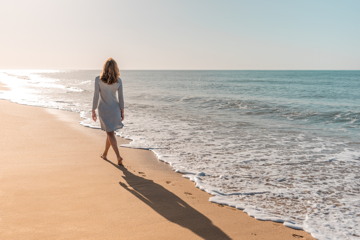 Woman walking on the beach during alcohol detox in Costa Mesa