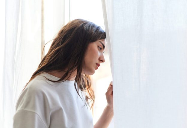 woman looking at window after mixing benzos and alcohol